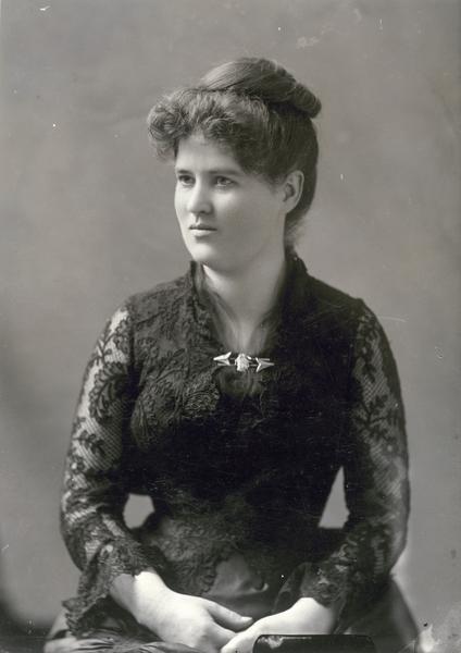 Formal studio portrait of Belle Case La Follette wearing a black lace dress. This photograph was taken about 1885, the year in which her husband, Robert M. La Follette, Sr., first went to Washington, D.C., as a Republican congressman. It is probably a dress that she wore to official parties and gatherings in the capital.