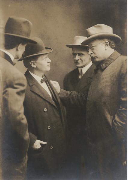 Group portrait of Emil Seidel talking with Fredrick C. Howe and Victor Berger, while another man stands off to the side.