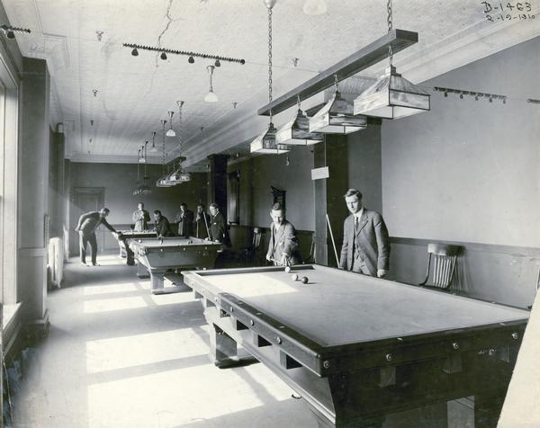Eight gentlemen playing billiards inside the Deering Works (factory) club house. The factory was originally built by William Deering for the Deering Harvester Company in 1880. In 1902 it became International Harvester's Deering Works. The factory was located at Fullerton and Clybourn Avenues and closed in 1933.