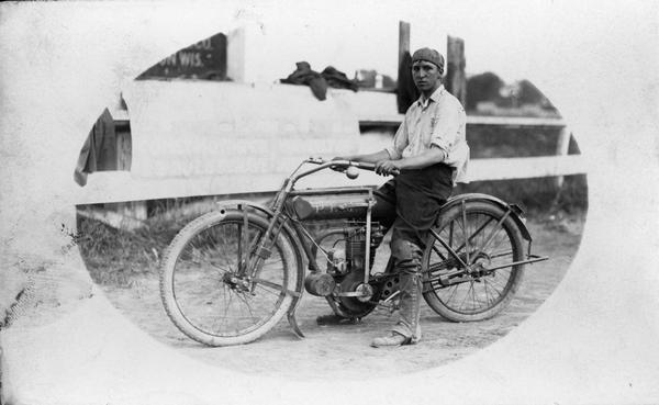 A young man sitting on a motorcycle.
