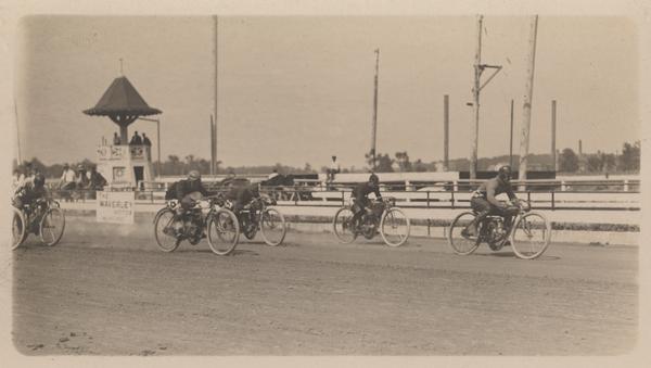 Motorcyclists race, probably at the Wisconsin State Fair Grounds.