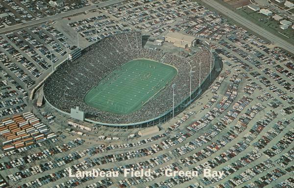 Aerial  view of Lambeau Field, home the Green Bay Packers football team, with a full parking lot. The capacity of the stadium at the time of this photograph was over 50,000. Caption reads: "Lambeau Field, Green Bay."