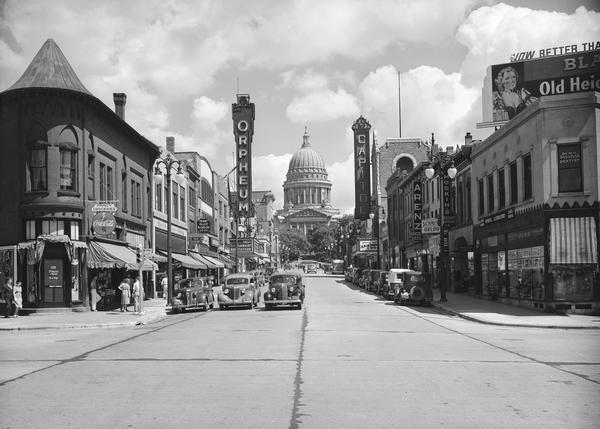 View looking east up State Street from Johnson Street, with the Orpheum and Capitol theatres on either side of the street, and the Wisconsin State Capitol.