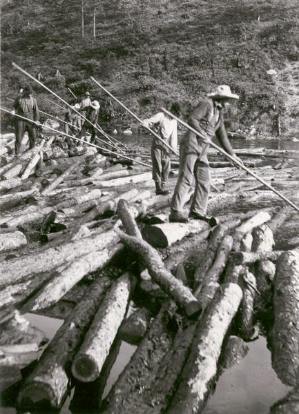 Loggers breaking up a log jam in the Peshtigo River area.