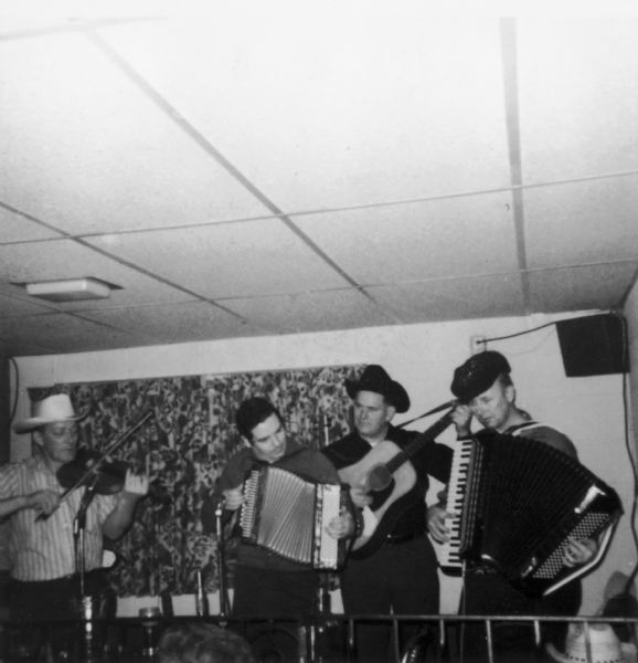 The Goose Island Ramblers performing at Johnny's Packers Inn.  Their instruments include accordions, guitar, and a fiddle. Tommy McDermott sits in on a button accordion.