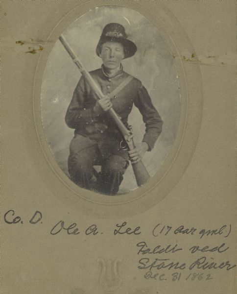 A seated studio portrait of Ole A. Lee, a private in Company D, 15th Wisconsin Infantry, in uniform, holding a musket across his chest.  The following information was obtained from the Regimental and Descriptive Rolls, Volume 20: He resided in Mt. Horeb, Wisconsin.  On February 10, 1862, he enlisted in Mt. Horeb, Wisconsin and on February 11, 1862, he was mustered into service in Madison, Wisconsin at the age of 17. He was killed in battle near Murfreesboro, Tennessee on December 31, 1862.