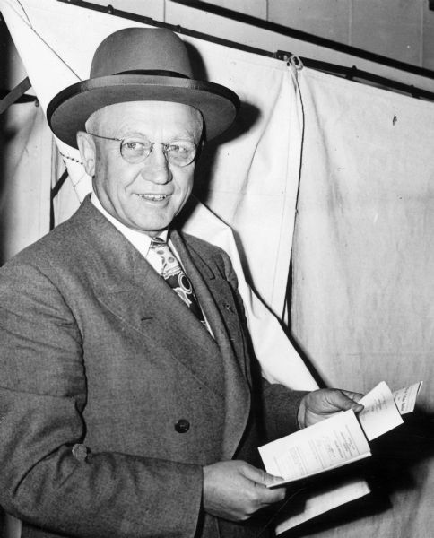 Governor Oscar Rennebohm outside a voting booth at the Maple Bluff village hall.  At the time, the Governor's Residence was located at 130 E. Gilman Street, but Rennebohm, the wealthy founder of Rennebohm Drug Stores, Inc., owned a large house in the exclusive village of Maple Bluff.  In 1949 the state purchased a new executive residence in Maple Bluff.
