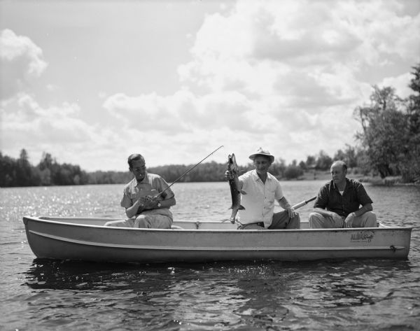 Edward R. Murrow and two men fishing from a boat on a northern Wisconsin lake.
