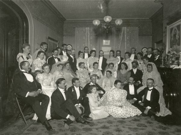 Group portrait of family and guests at A.E. Proudfit's silver wedding anniversary party, which took place at the Morris residence.