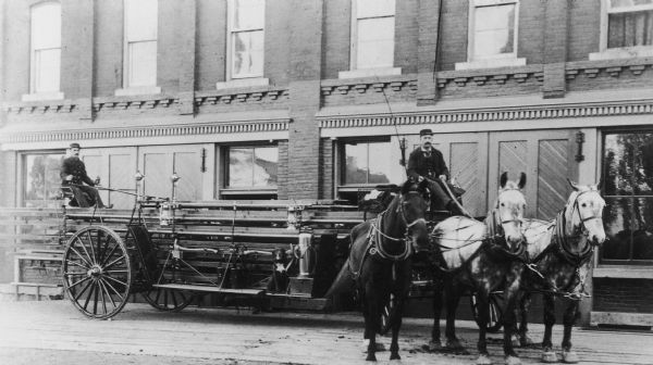 Madison fire fighters with W.H. Rogers Company horse-drawn wagon in front of the old Central Fire Station, 10 South Webster Street.