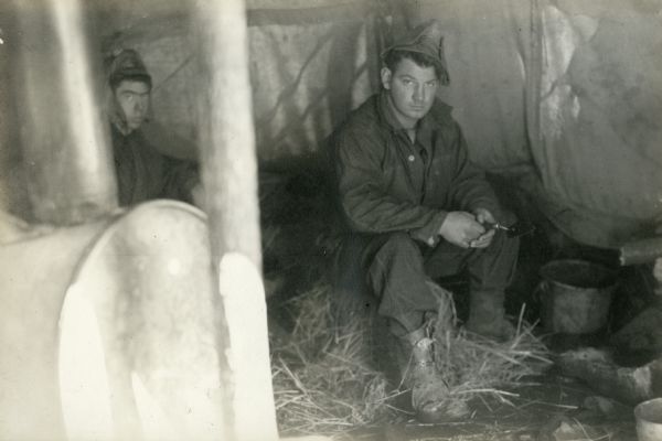 Two men seated inside a tent at the digging site at Interstate Park.