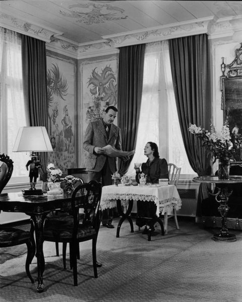 Alfred Lunt and Lynn Fontanne discuss the newspaper in their drawing room at Ten Chimneys.