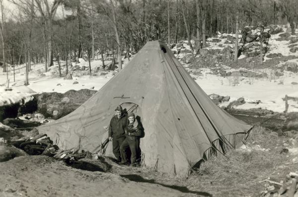Tent covering the excavation site of the bones of extinct bison. Milo Mickelson and Lester Giesler are standing in the doorway of the tent.