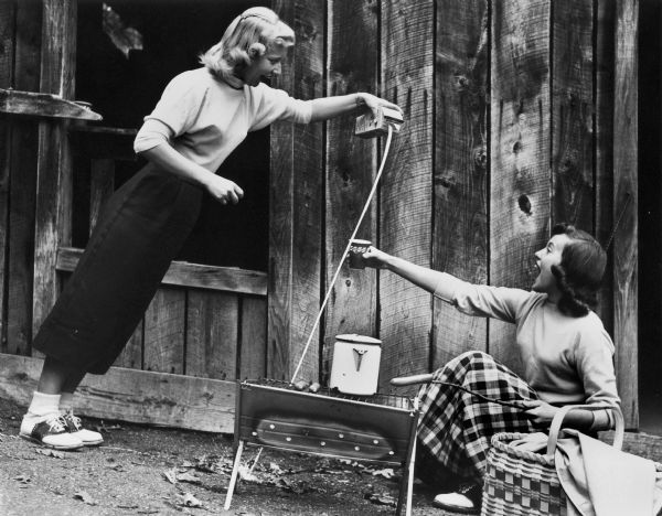 Nancy Waterman unsuccessfully pours milk for Harriet Anderson (whose name has since changed to Penny Hilley) at the Wonder Spot.
