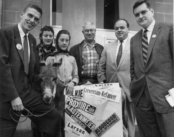 Six people pose with a donkey and stickers for Democratic candidates. From left to right are Norman Anderson, Linda Colby, Jackie Colby, Harold Hill, H.W.W., and Joseph Bloodgood.