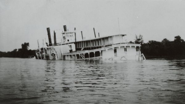 Sidewheel packet <i>Quincy</i>, sinking. Only her two upper decks are above water. Trempealeau Mountain is in the background. Later renamed the <i>J.S.</i>