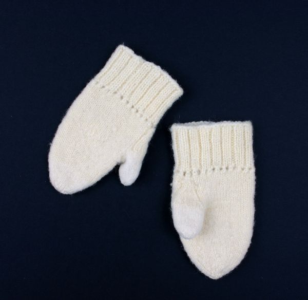 Baby mittens knitted from off-white wool yarn.