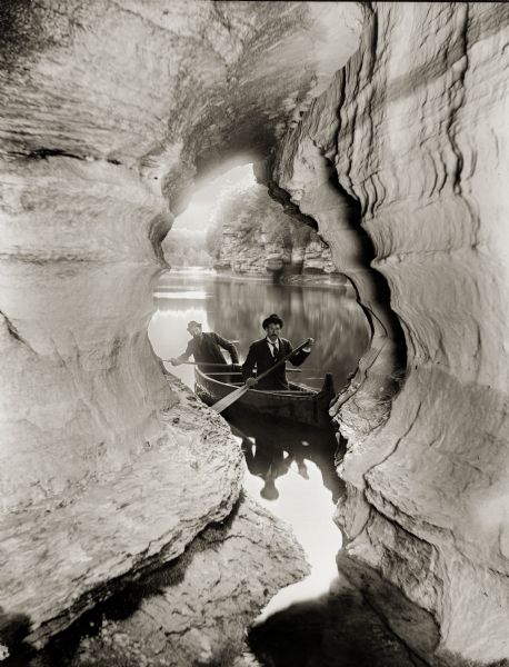 Out of Boat Cave Two men navigating their canoe through caves at the Wisconsin Dells.