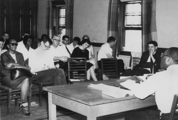 Student Leadership Conference, May 4-6, including Ella Baker (front row, far left), Carl Braden (second row, hands clasped around knees), Anne Braden (second row, black dress), and Tom Hayden (right of window in dark jacket).