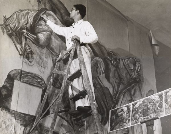 Santos Zingale (1908-1999), then an unemployed artist, working on the cartoon phase of a WPA mural he was painting in Racine. The preliminary sketch from which he is working can be seen at the lower right. In 1946 Zingale joined the University of Wisconsin Art Department, where he continued to teach until his retirement in 1946.