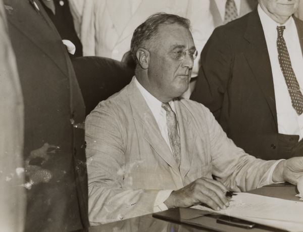 President Franklin D. Roosevelt about to sign the Social Security Act of 1935.