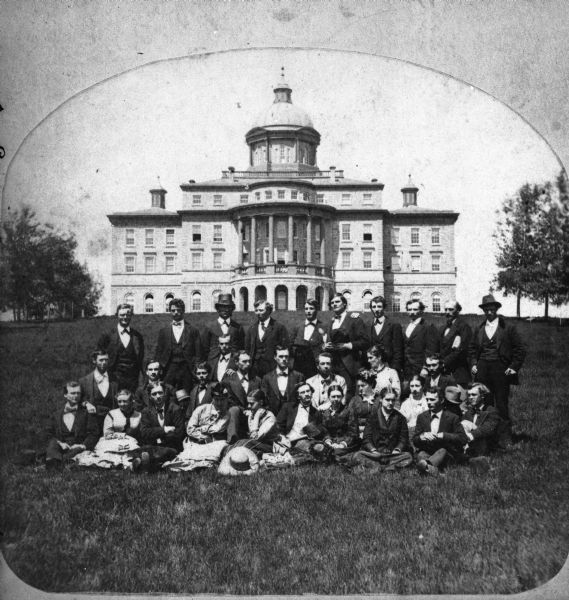Group portrait of University of Wisconsin students, perhaps a graduating class, on the lawn in front of Main Hall (later Bascom Hall).