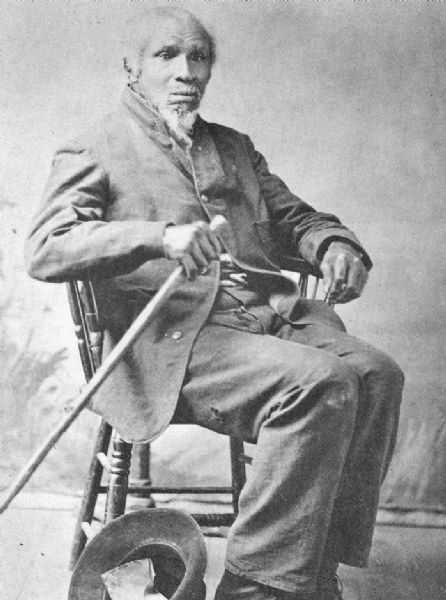 Portrait image of Stephen Bonga (1799-1884) pictured with a hat and walking stick. 

