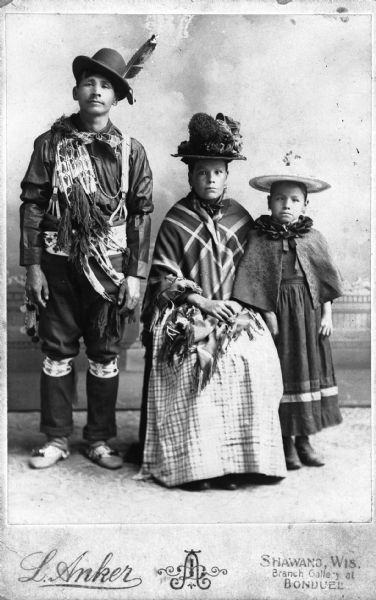 Studio portrait of the Menominee family of Kaw-hee-she-uh-quat in formal attire.