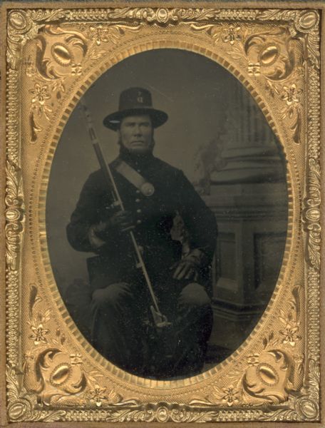 Quarter plate ferrotype/tintype of Peter Larsen in a Civil War uniform holding a firearm.