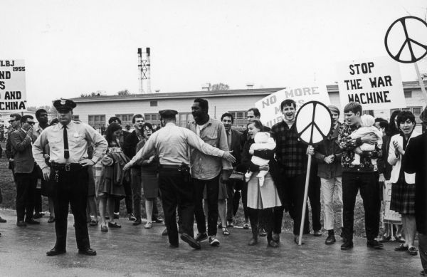 Opponents of the War in Vietnam protesting at Truax Air Force Base.  This event, which was probably sponsored by local members of the National Coordinating Committee Against the War in Vietnam, was one of the first demonstrations against the war in Madison.