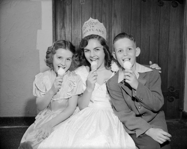 Marjean Czerwinski of Milwaukee, the 1951 Alice in Dairyland, poses eating an ice cream cone with a young boy and girl.