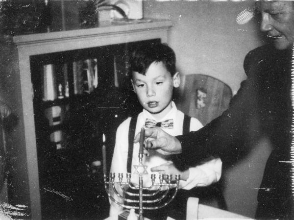 Edward (son of Eva Lauffer Deutschkron and Martin Deutschkron) during the lighting of Hanukkah candles.