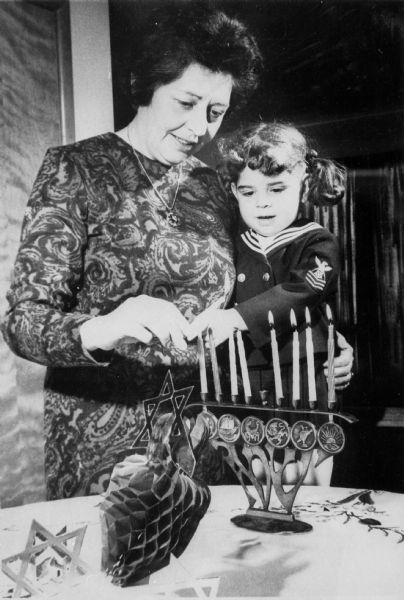 Rosa Goldberg Katz and her daughter, Marilyn, lighting Hanukkah candles in their home.