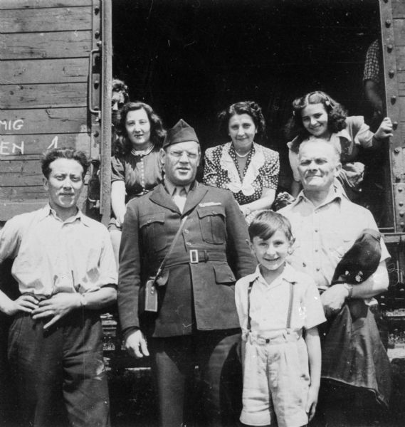 Refugees on their way to Bremerhaven, Germany to sail to the United States. The man in the center is Max Neumann, director of HIAS in Germany. On the left is the Weinschenker family. Frieda Weinschenker is seated in the train doorway on the far right and next to her is her mother Klara Weinschenker. Standing in front of Frieda is her father Chaim Weinschenker, and standing in front of him is Frieda's brother Milo Weinschenker.

