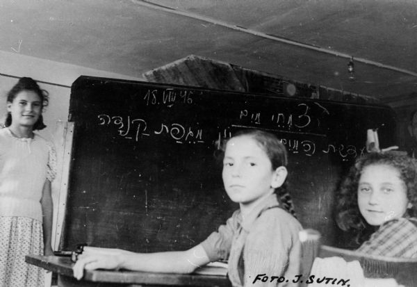 Refugee children learning Hebrew at a displaced persons camp school; Germany.

Saul Sorrin was interviewed as part of the Wisconsin Survivors of the Holocaust Interviews project. Sorrin, born in New York in 1919, applied in 1940 for a position with the United Nations Relief and Rehabilitation Administration (UNRRA). He worked with Holocaust survivors as a supply officer for UNRAA team 560 at the Displaced Persons camp Neu Freimann Siedlung in Germany and later, at General Dwight D. Eisenhower's recommendation, Sorrin became the Area Director of the International Refugee Organization based at the Wolfratshausen DP camp in Bad Kissingen.

When asked about this image, Sorrin revealed, "I can even see the date on this: August 18, 1946.  It's a classroom in Hebrew.  The children there--we had a strong urge to education and we had schools set up.  We had a hard put to find teachers but we found them and teaching materials.  I'm not sure which camp this is in."

Interview by Jean Loeb Lettofsky and David Mandel, March 3, 1980.