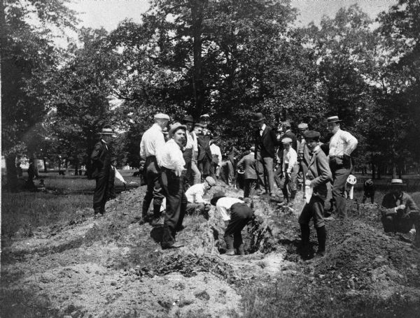 A group of children and adults excavating an oval mound in the Teller Group.