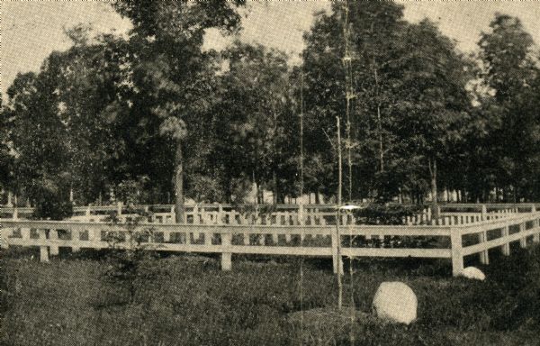 "Confederate Rest" in Forest Hill Cemetery where Confederate prisoners of war who died at Camp Randall are buried. In this early photograph, there is a wooden fence surrounding the plot and the graves are marked with wooden headboards.