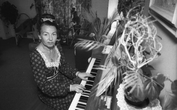 Magda Herzberger sits at the piano at her home.