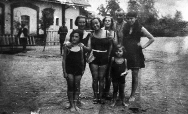Magda Moses Herzberger (child at center) standing with relatives dressed in bathing suits in front of a resort in Turda, Romania.
