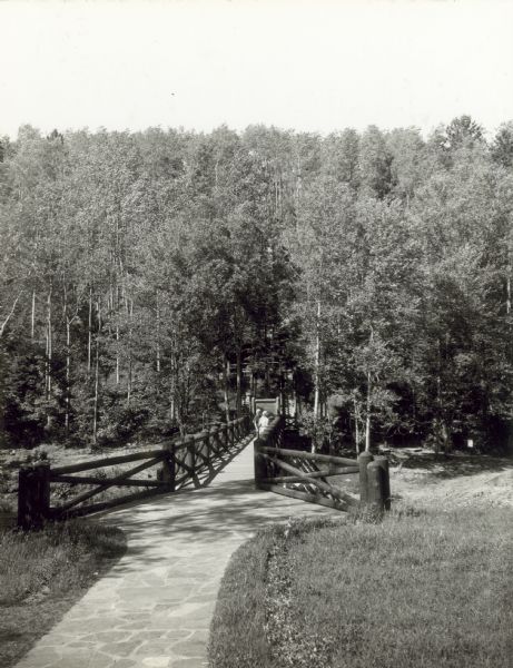 Two people on a rustic bridge over Bad River at Copper Falls State Park.
