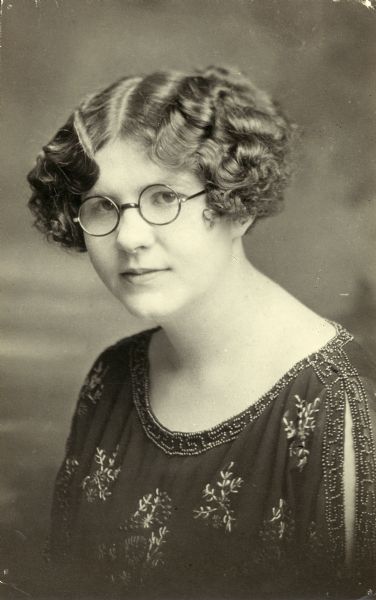 Head and shoulders studio portrait of Mildred Barber, wearing eyeglasses and a beaded blouse, of Marathon, Wisconsin.