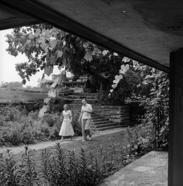 View of the courtyard of Taliesin, the summer home of Frank Lloyd Wright, from the covered entrance. A man and a woman are walking through the courtyard. Taliesin is located in the vicinity of Spring Green, Wisconsin.