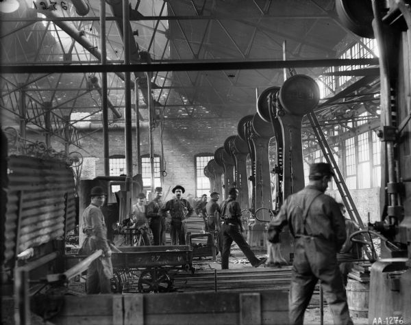 Men working in the forge shop of the McCormick Reaper Works. The factory was owned by the McCormick Harvesting Machine Company. In 1902 it became the McCormick Works of the International Harvester Company. The factory was built in 1873 and was located at Blue Island and Western Avenues in the Chicago subdivision called "Canalport."