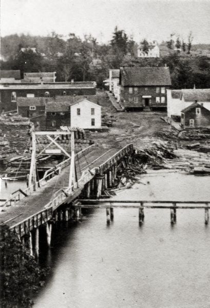 Elevated view of a bridge and logging debris around residential homes.