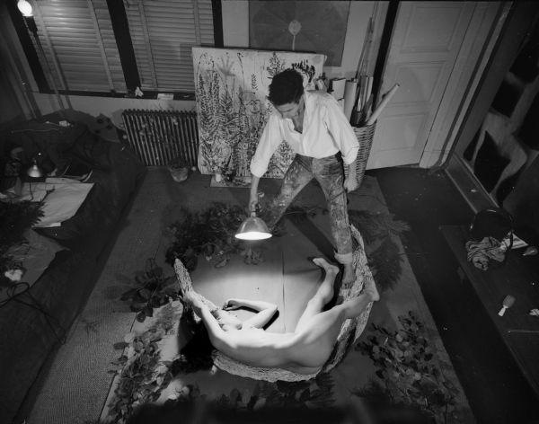 Robert Rauschenberg makes cyanotype art by shining a light over a nude female model who is lying on photosensitive blueprint paper. The print was to be used in the construction of a Japanese screen.