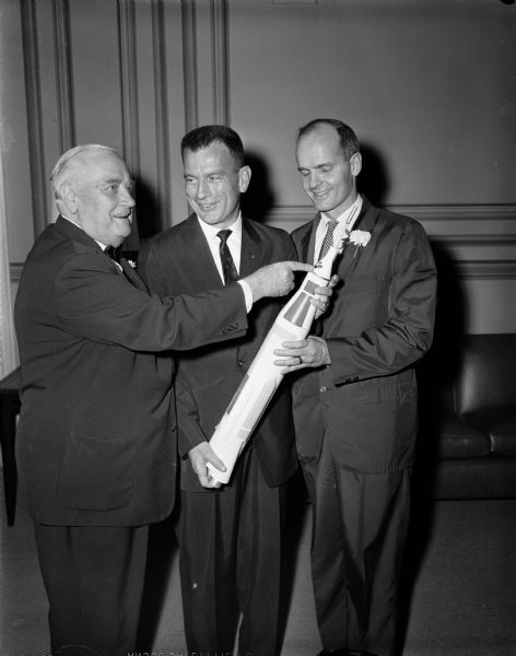 Senators Alexander Wiley and William Proxmire posing with astronaut Donald K. Slayton and a model of a rocket.