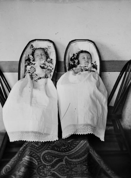 Studio portrait of deceased twin infants in coffins. They are Robert and Janet Fitzpatrick, born July 5, 1885, died April 20, 1886, children of Robert and Martha Fitzpatrick.