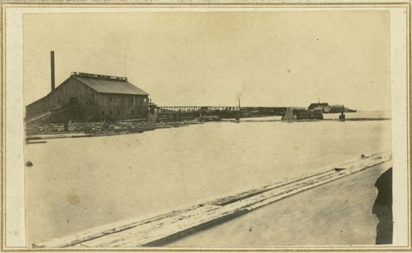 An exterior view across water of Robert Stephenson & Company Mill, which was a steam mill.