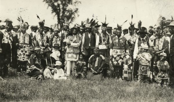 Large group portrait of Lac Courte Oreilles Indians in traditional garb at the Victory Festival.