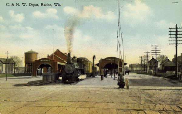 View of the Chicago & Northwestern Railroad depot. A train rests at the stop while commuters wait to board from the platform. There is a horse to the right of the passenger platforms. Telephone (or telegraph) poles line the right side of the image with residences in the background. Caption reads: "C. & N. W. Depot, Racine, Wis."